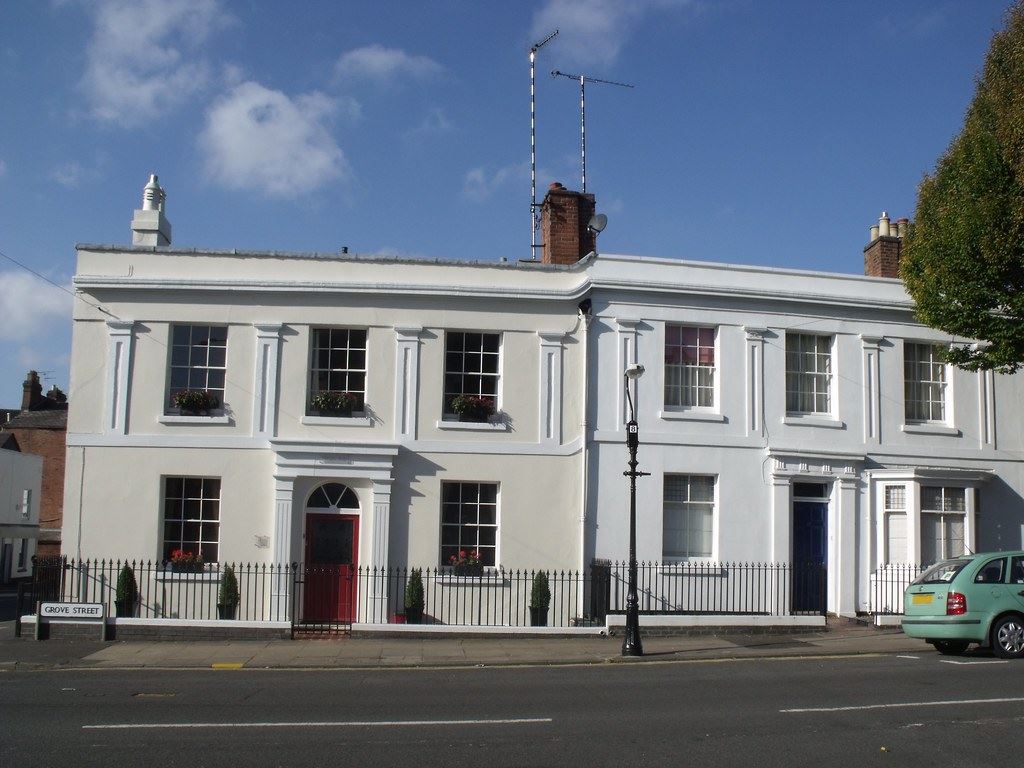 A terrace of Georgian houses with sash windows and a car parked at the kerb